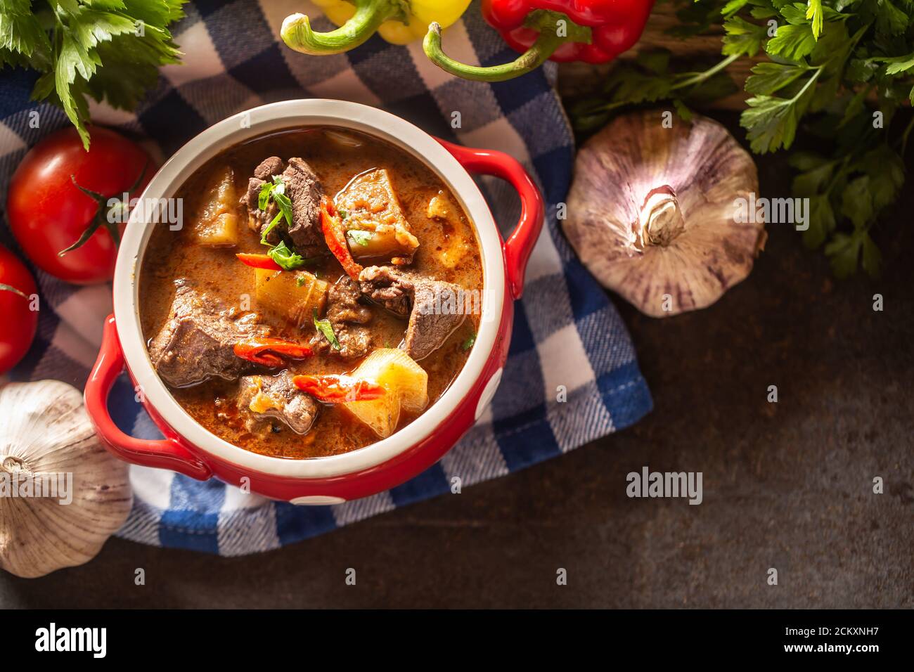 Blick von oben auf eine Schüssel Gulaschsuppe mit Fleisch, Kartoffeln und Chilis Stockfoto