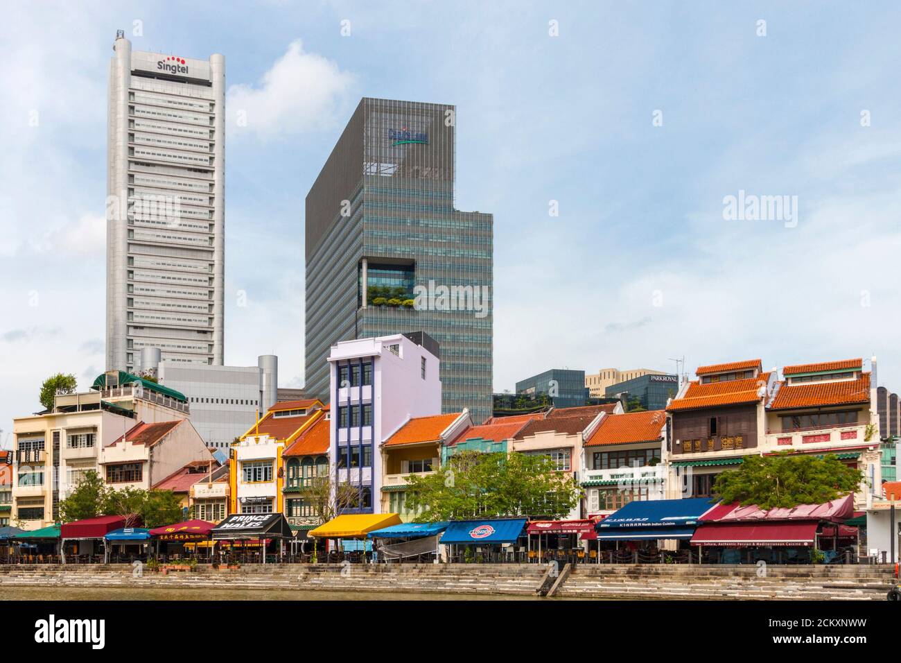 Etwas modernere Ladenhäuser säumen den Singapore River und werden von glänzenden, modernen Hochhäusern unterlegt. Ladenhäuser sind meist zwei oder drei Stockwerke hoch, mit einem Geschäft im Erdgeschoss für Handelsaktivitäten und einer Residenz über dem Geschäft.Dieses hybride Gebäude ist in den historischen Zentren der meisten Städte in der Region Südostasien beliebt. Stockfoto