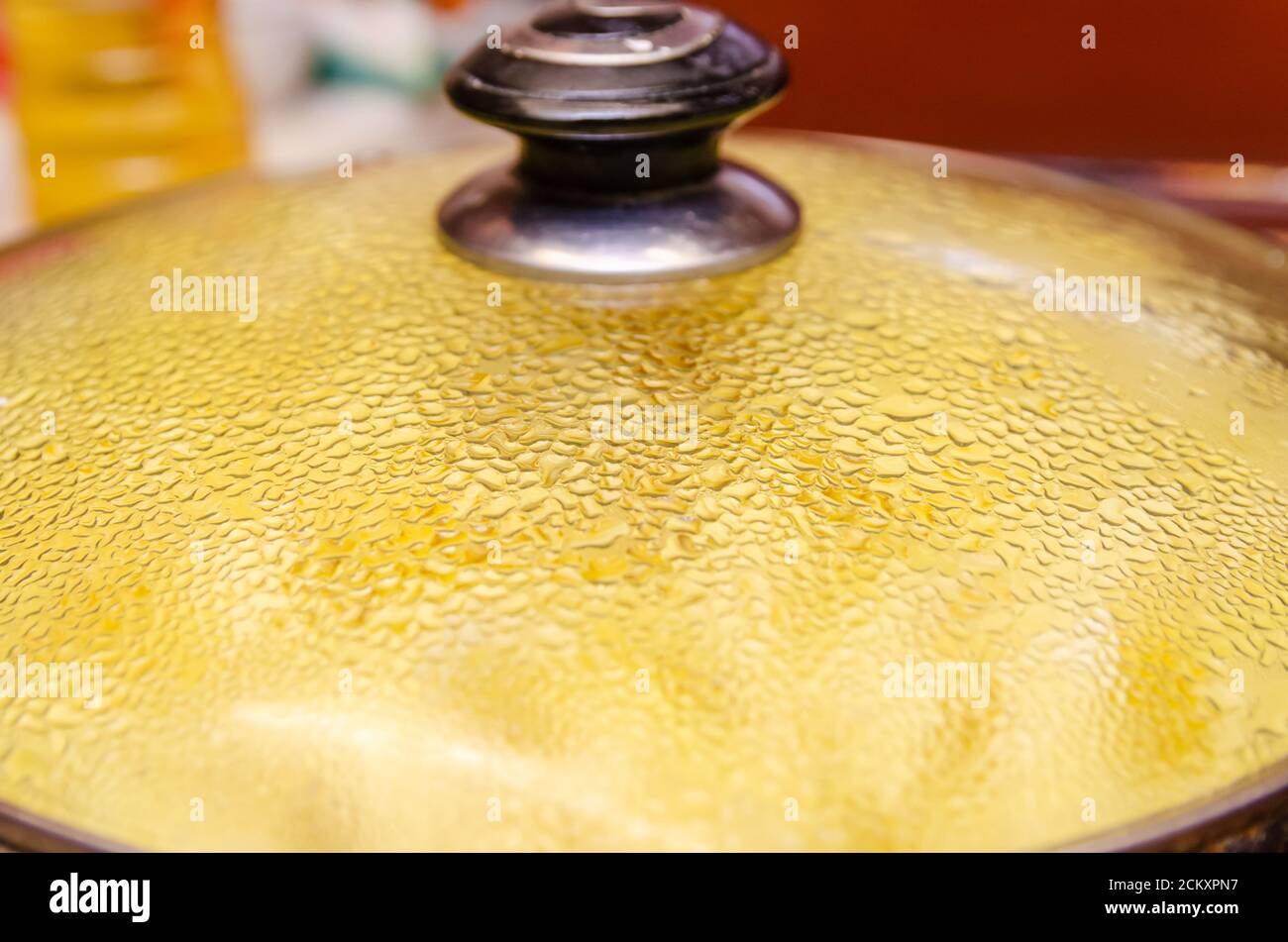 Kartoffeln werden in einer Pfanne unter dem Deckel gebraten Mit Wassertropfen aus nächster Nähe Stockfoto