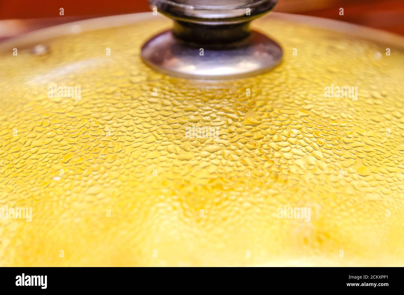 Kartoffeln werden in einer Pfanne unter dem Deckel gebraten Mit Wassertropfen aus nächster Nähe Stockfoto