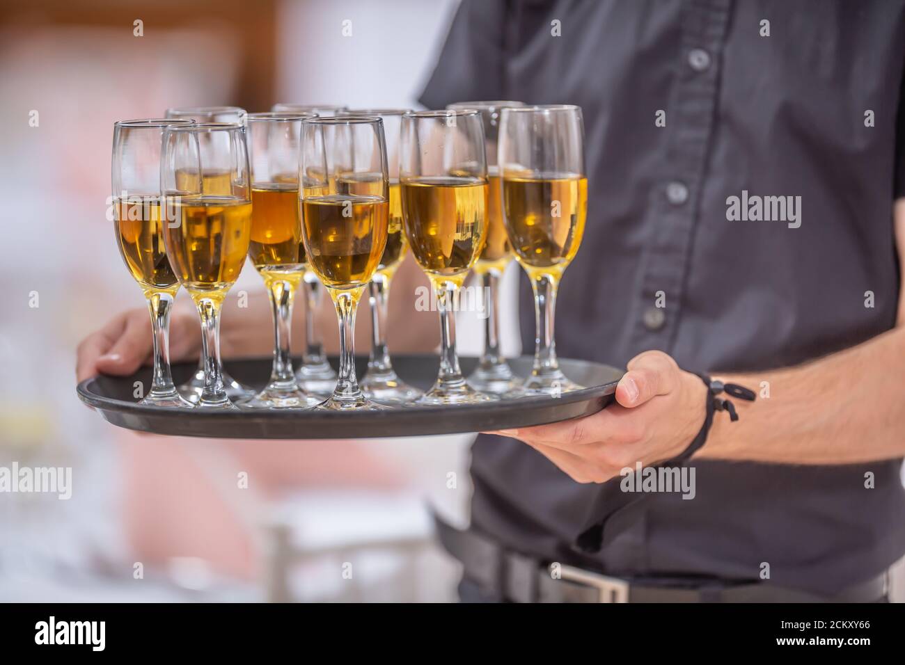 Der Kellner hält ein Serviertablett voll mit Getränken in Champagner Brille Stockfoto
