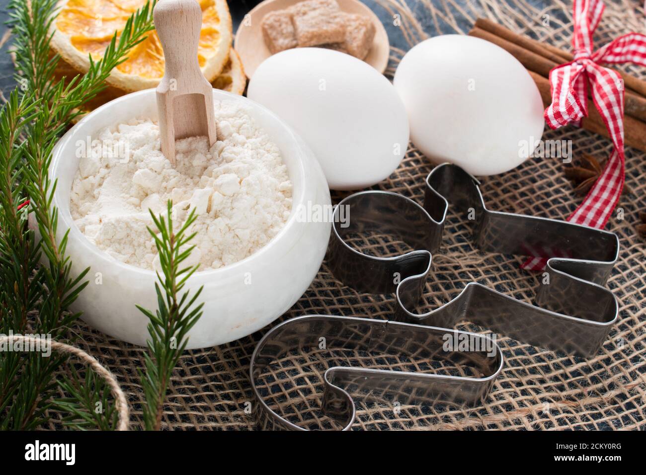 Metall-Ausstechformen und Kochzutaten. Mehl und Eier sind auf einer Serviette. Weihnachtsessen. Stockfoto