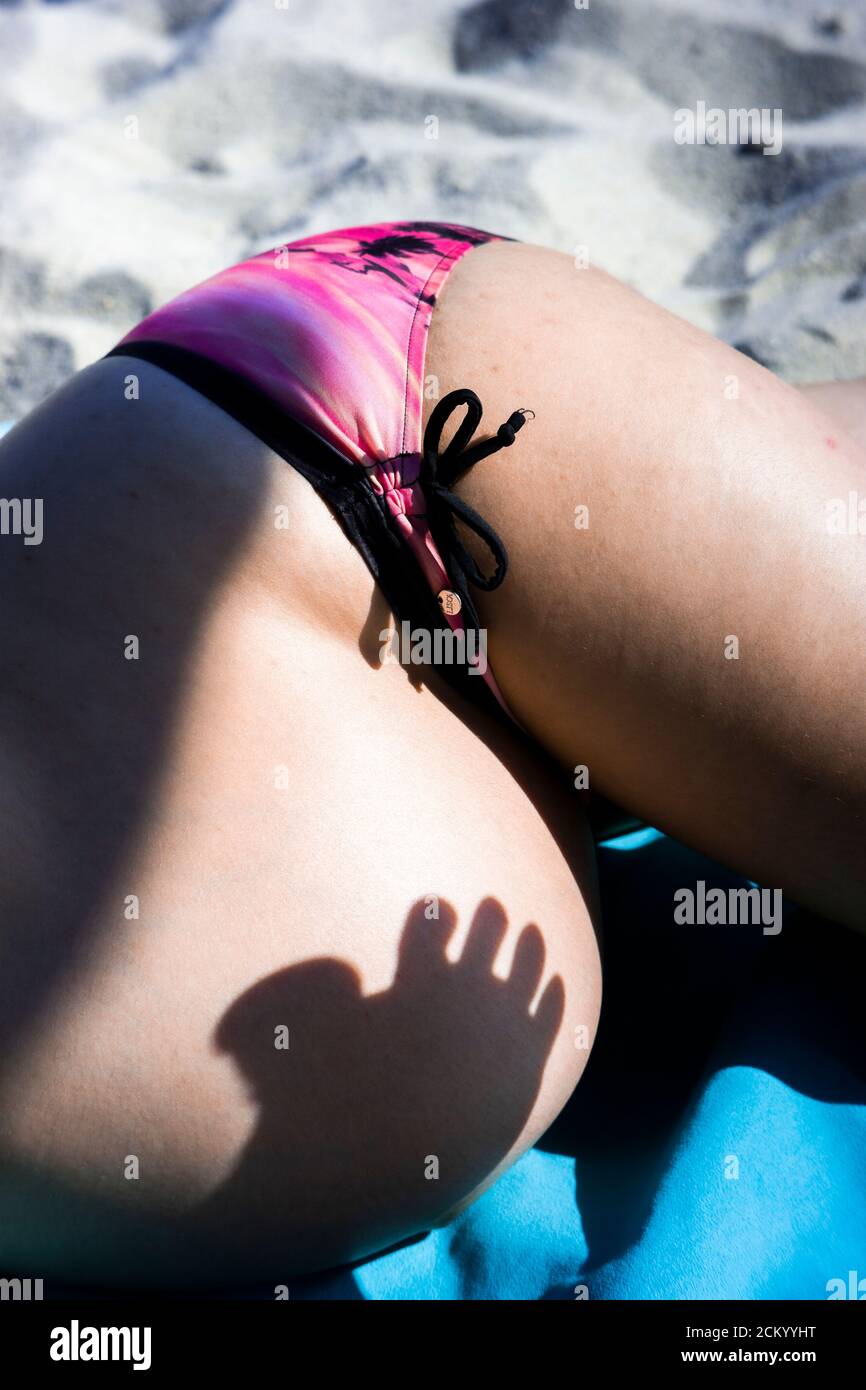 Schwangere Frau liegt am Strand mit einem lustigen Fuß Schatten Stockfoto
