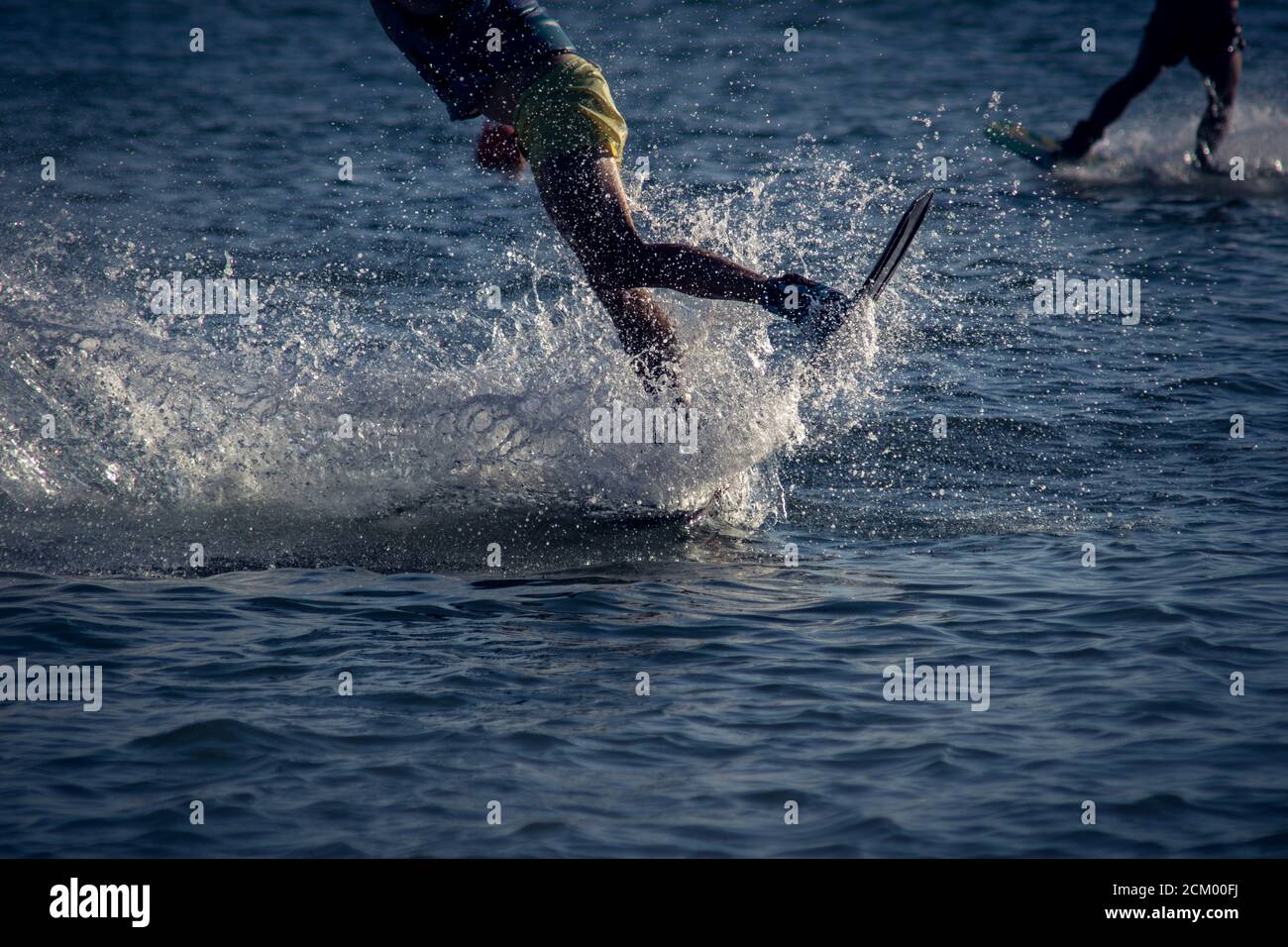 WAKEBOARDING AUF DEM MEER LANDUNG VON EINEM SPRUNG. KONZEPT DES EXTREMSPORTS IM WASSER Stockfoto