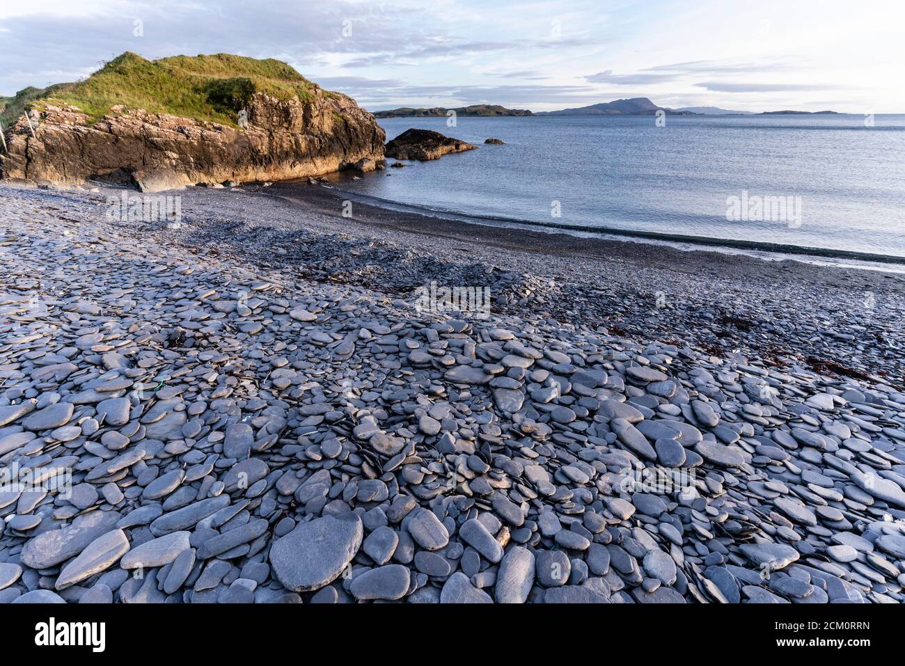 Der einzigartige Schieferstrand von Ellenabeich auf der Insel Seil, Argyll, Schottland, wo ein ehemaliger Schieferbruch ein Wellenbrecher und eine Lagune schuf. Ort der Steinabsauen Stockfoto