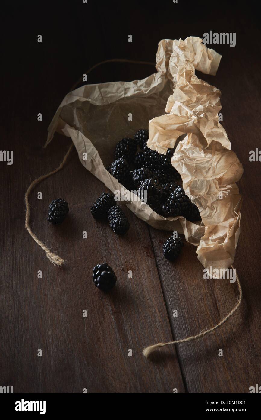 Brombeeren verschüttet auf dem Tisch aus Papier Verpackung Stockfoto