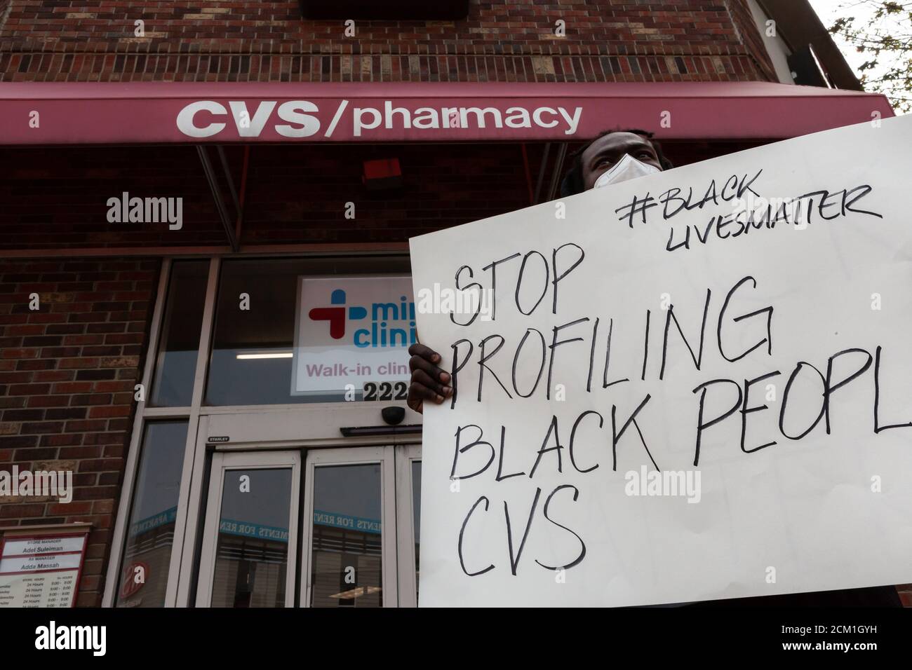 Washington, DC, USA, 16. September 2020. Im Bild: Ein Protestler am Eingang zum CVS hält ein Schild mit der Aufschrift "STOP Profiling Black People, CVS". Der Protest fand statt, weil am Tag zuvor der CVS-Store-Manager die Polizei wegen zweier 'suspicious' schwarzer Männer anrief. Sechs Metropolitan (DC) Polizeibeamte nahmen die beiden Männer fest und ließen sie schließlich frei, nachdem eine Durchsuchungsstelle keine gestohlenen Gegenstände gefunden hatte. Angesichts der erheblichen Gefahr von Gewalt, wenn die Polizei auf schwarze Männer gerufen werden, kam eine Reihe von Menschen, um gegen die Entscheidung des Managers zu protestieren. Kredit: Allison C Bailey/Alamy Stockfoto