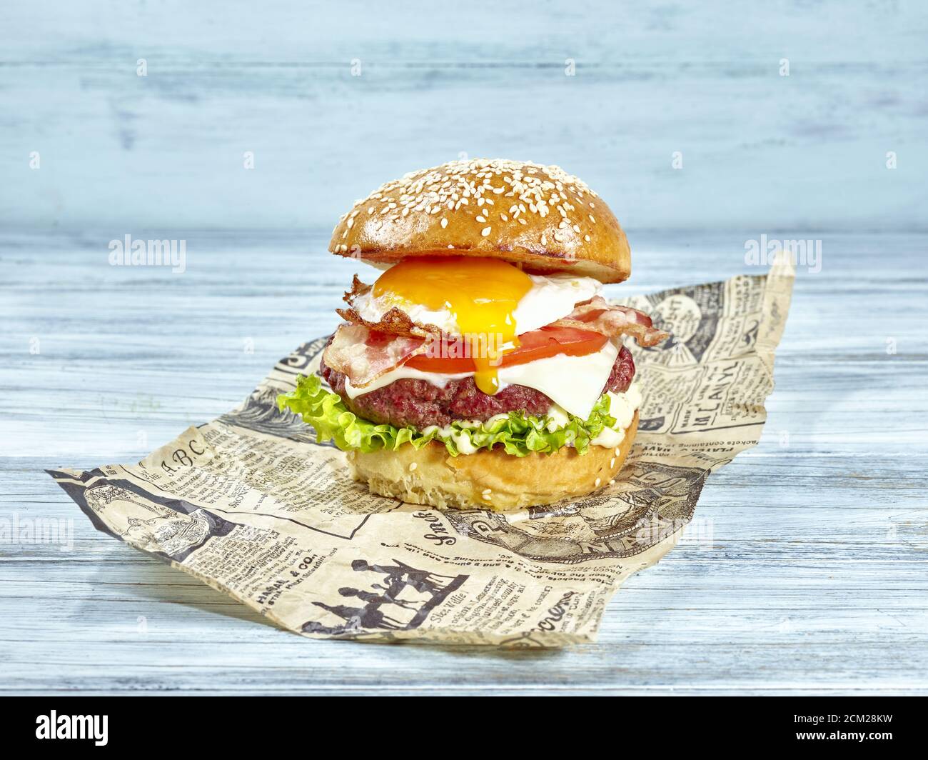 Gebratenes Ei Hamburger aus Butter Brötchen mit Salat auf Mayo-Aufstrich, Saft Hamburger und Käse, frische Tomaten gekrönt von knusprigen gebratenen Speck und f Stockfoto