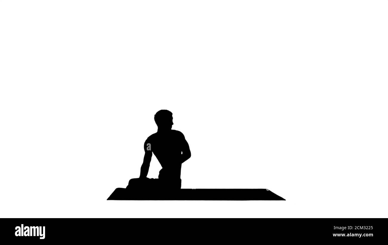 Silhouette EIN junger starker Mann tut Yoga-Übungen dehnt Pad Stockfoto