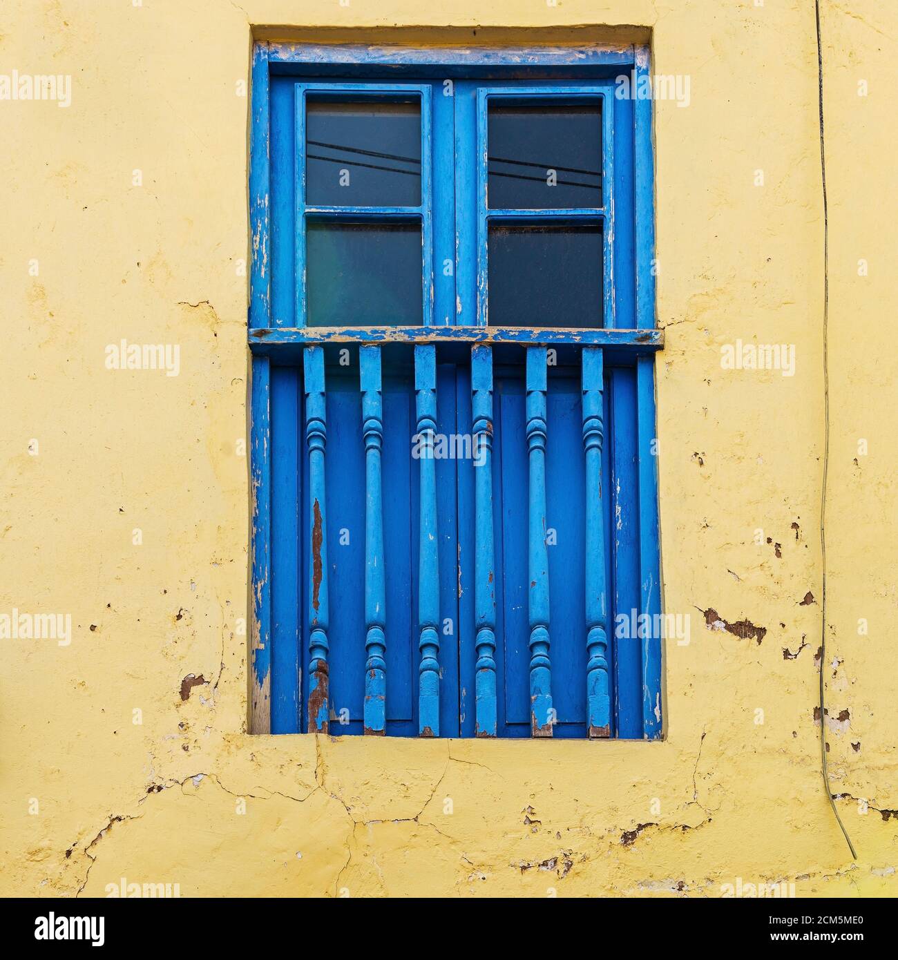 Blaues Balkonfenster im Kolonialstil und gelbe Fassade, Cusco, Peru. Stockfoto