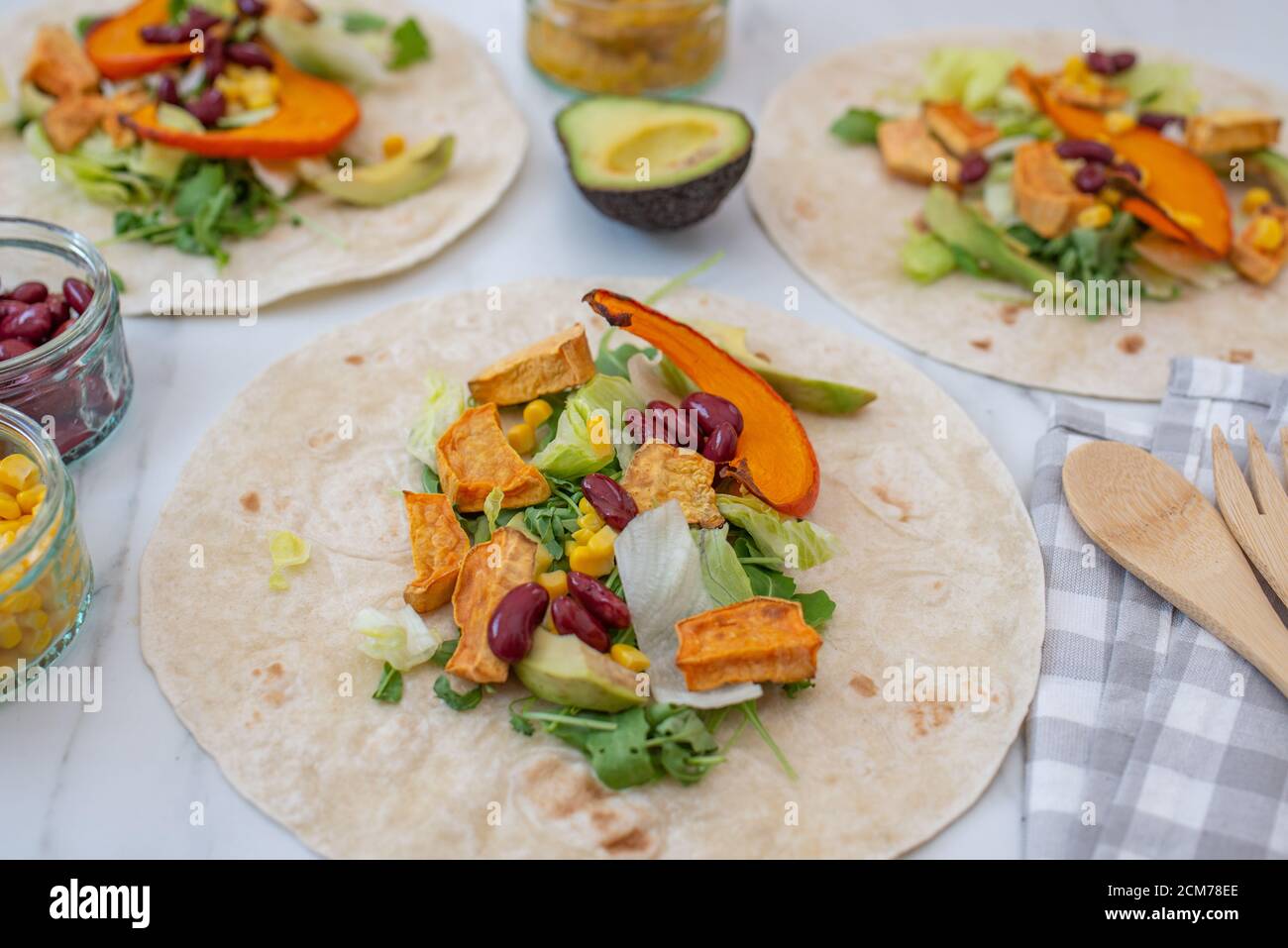 Offene vegane Tortilla Wraps mit Süßkartoffeln, Bohnen, Avocado und Kürbis Stockfoto