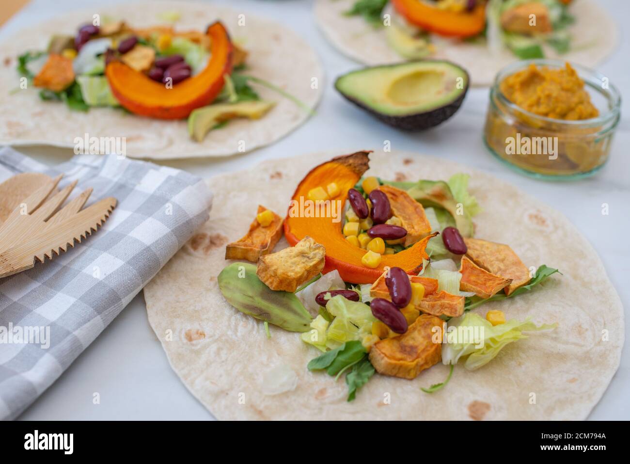 Offene vegane Tortilla Wraps mit Süßkartoffeln, Bohnen, Avocado und Kürbis Stockfoto