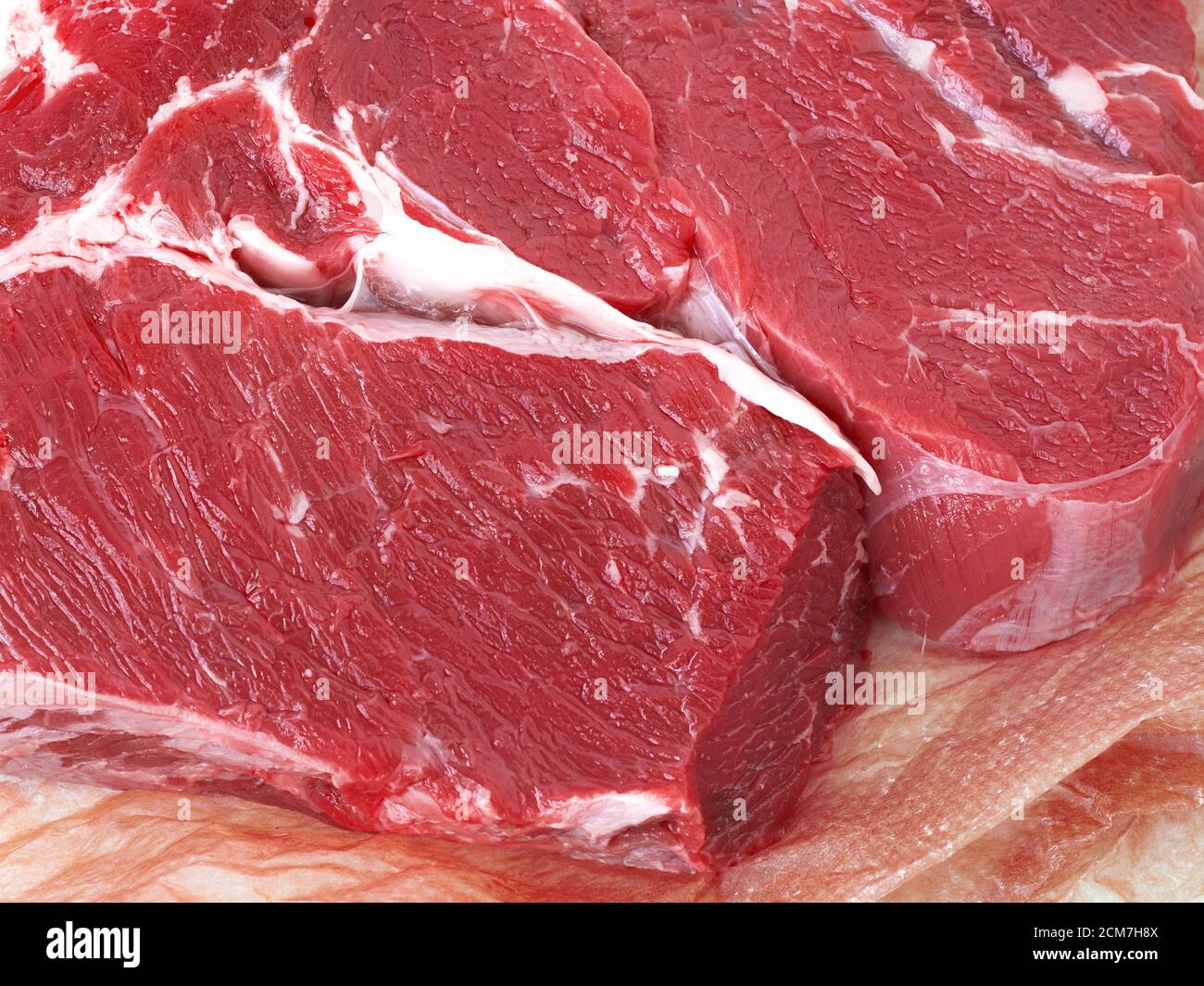 Frisches Stück Rohes Rindfleisch auf Geschenkpapier. Nahaufnahme der Details rohes Rindfleisch Fleisch. Draufsicht Stockfoto
