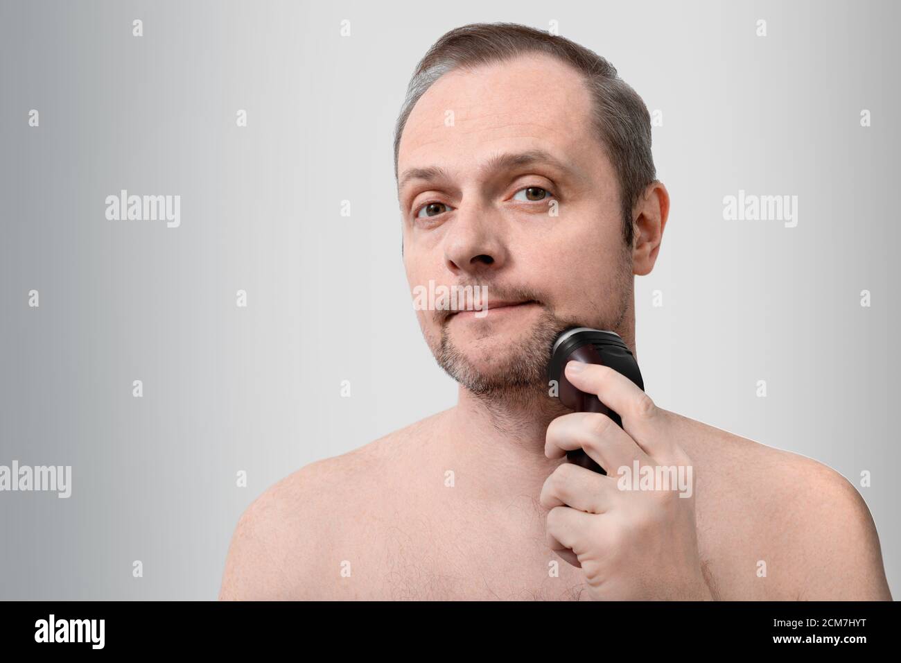 Schöner Mann rasiert mit einem elektrischen Rasiermesser, 35-40 Jahre alt Stockfoto
