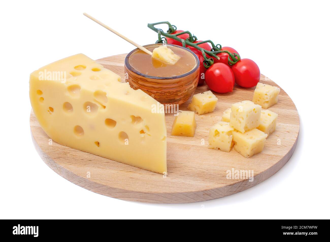 Gelber Maasdam-Käse, dreieckiger Käse mit Löchern, Untertasse mit Honig, Tomatenholz isoliert weißen Hintergrund Stockfoto