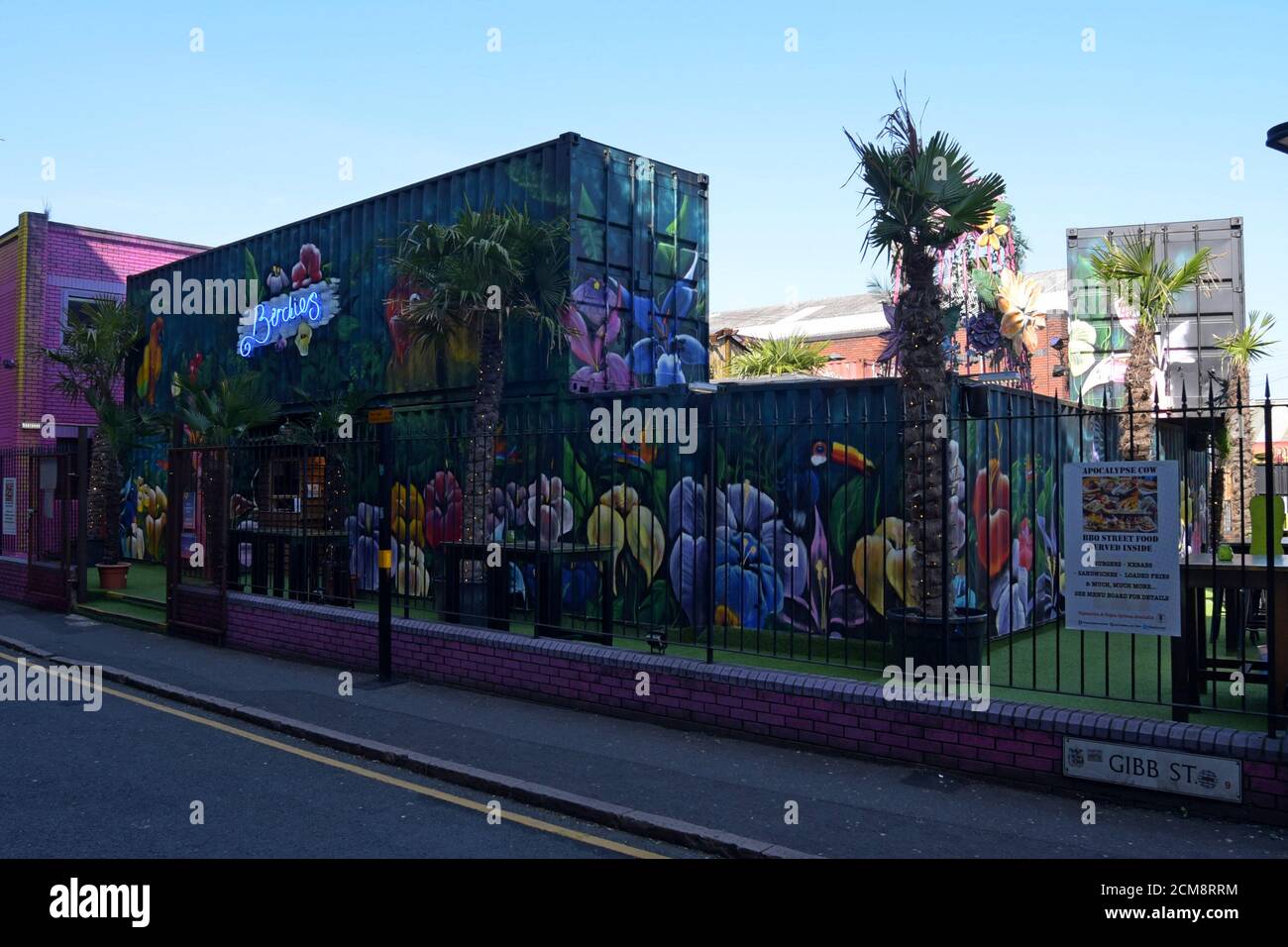 Recycelte Transportbehälter mit lebhaften Wandgemälden im Straßenkunstwerk schaffen einen Barbereich im Freien in der Birdies Bar und Grill in Digbeth, Birmingham Stockfoto