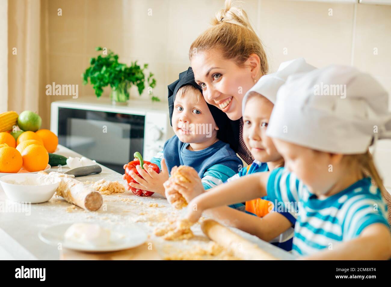Glückliche Familie in der Küche, die Mutter und Kinder bereiten den Teig, Backen Sie Plätzchen Stockfoto