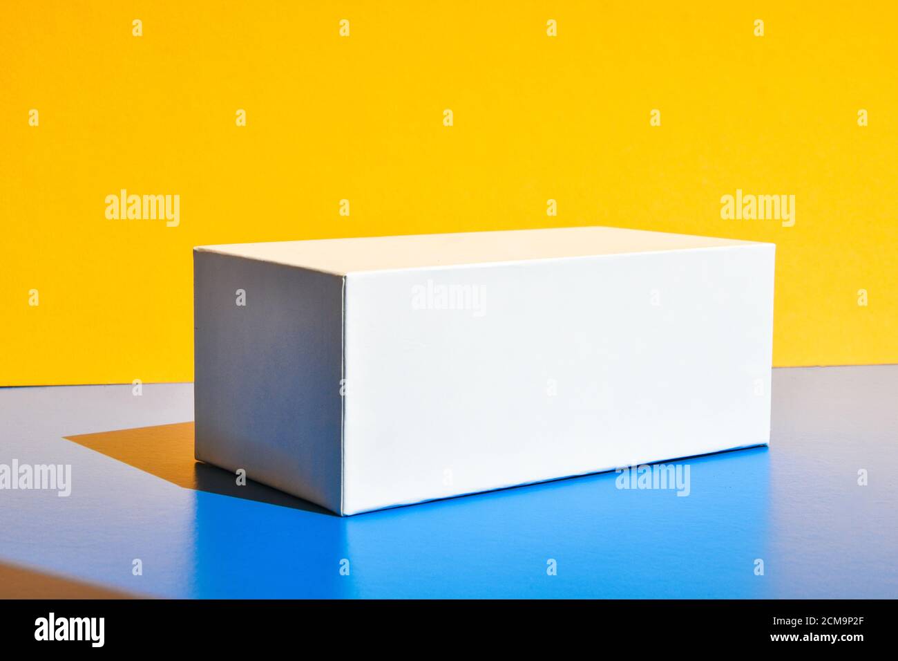 Weißes Feld. Modell der Drogenbox. Modell. Speicherplatz kopieren. Gelb und blau kreativen Minimalismus isometrischen Hintergrund Stockfoto