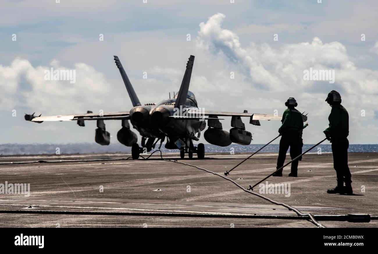200916-N-DL524-1089 PHILIPPINE SEA (SEPT 16, 2020) die Gefährten (Equipment) der Luftfahrtboatswain ziehen einen festhaltenden Draht zurück, nachdem ein EA-18G Growler, der an den Shadowhawks of Electronic Attack Squadron (VAQ) 141 befestigt ist, auf dem Flugdeck des einzigen vorwärts eingesetzten Flugzeugträgers USS Ronald Reagan (CVN 76) der Marine landet, um Valiant Shield 2020 zu unterstützen. Valiant Shield ist ein US-amerikanisches, zweijähriges Field Training Exercise (FTX) mit dem Schwerpunkt auf der Integration von gemeinsamen Schulungen in einer Blue-Water-Umgebung unter US-Streitkräften. Diese Schulung ermöglicht die praktische Erzielungen bei der Aufrechterhaltung gemeinsamer Kräfte durch Detect Stockfoto