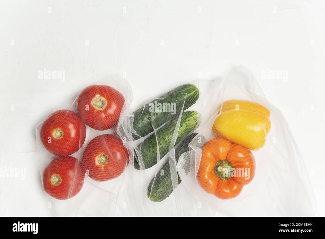 Wiederverwendbare Beutel mit, frisches Gemüse Tomaten, Gurken, Paprika auf weißem Hintergrund, Zero Waste Konzept Stockfoto