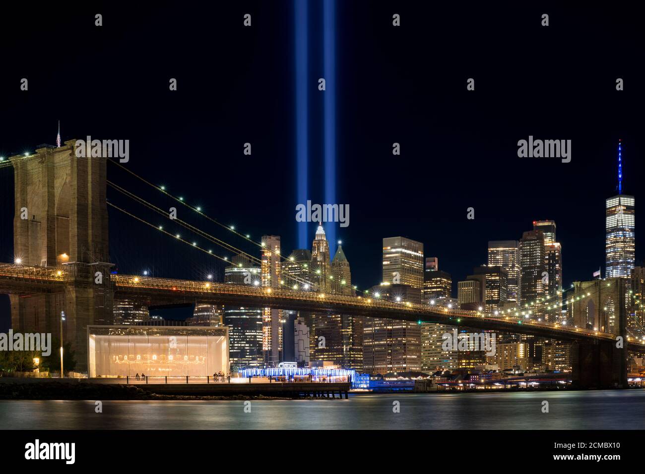 9/11 Tribute im Licht. Brooklyn Bridge und Lower Manhattan bei Nacht beleuchtet. Blick vom Main Street Park. Stockfoto