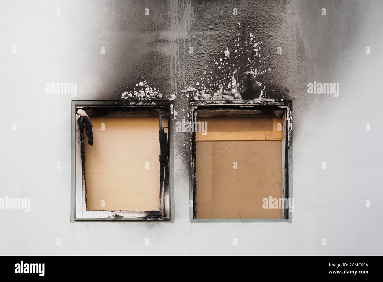 Haus oder Haus Feuer - vernagelt Fenster und verbrannt Fassade geschwärzt durch Ruß des modernen Wohnhauses Stockfoto