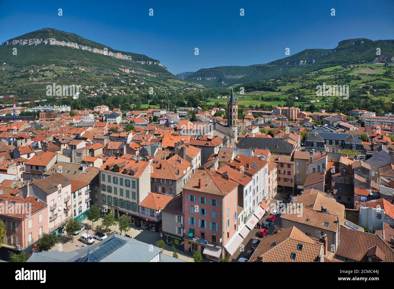 Blick auf den Stadtplatz und die roten Ziegeldächer der Stadt Millau, Aveyron, Frankreich, mit Hügeln in der Ferne Stockfoto