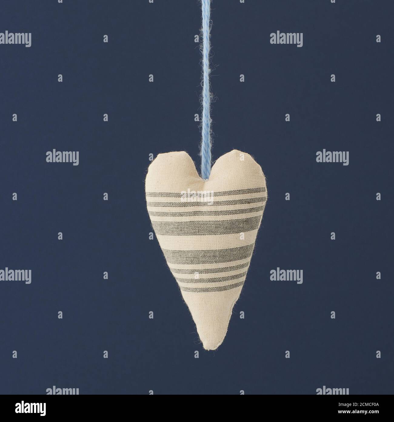 Hängendes Herzgewebe auf blauem Hintergrund. Stockfoto