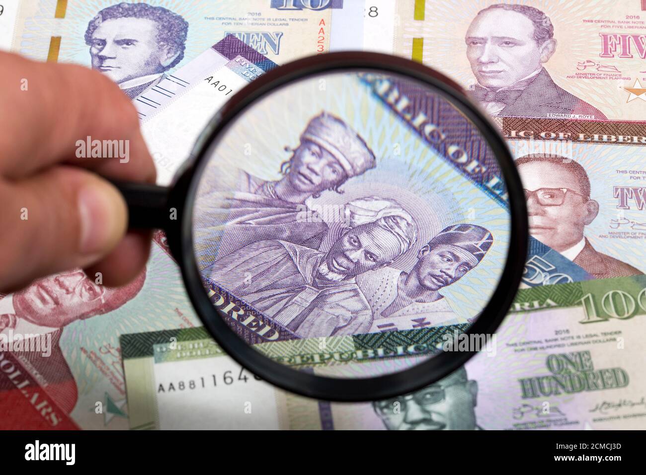 Liberianische Geld in einer Lupe ein geschäftlicher Hintergrund Stockfoto
