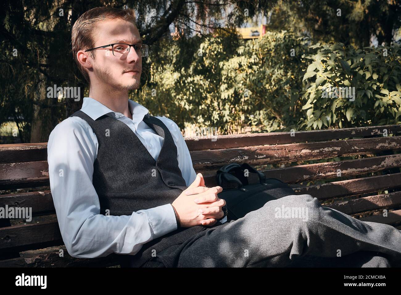 Büroangestellter sitzt auf der Bank im Park Stockfoto