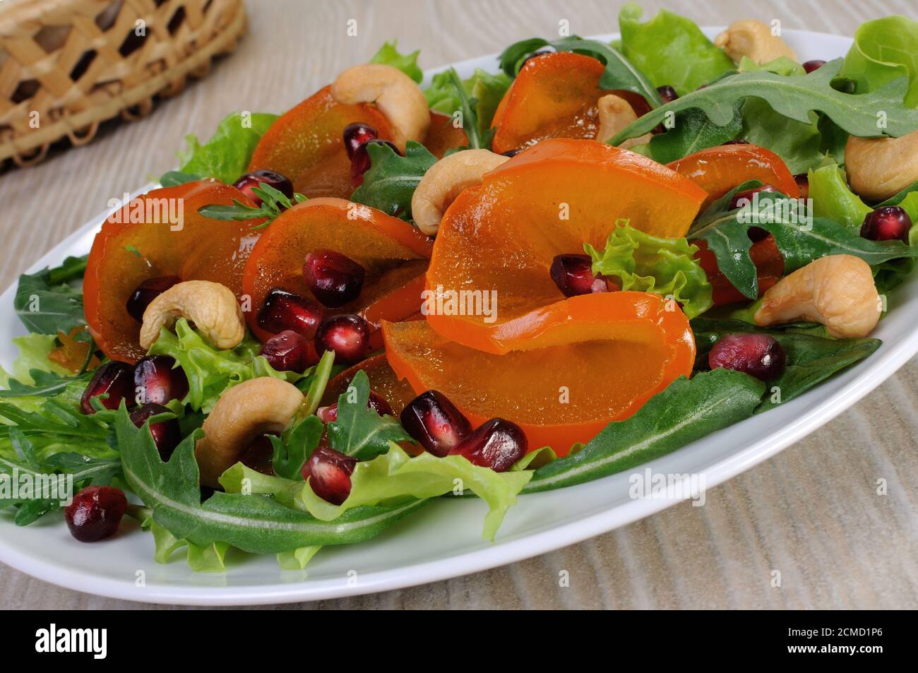 Salatgrün mit Kaki, Granatapfel und Cashews Stockfoto