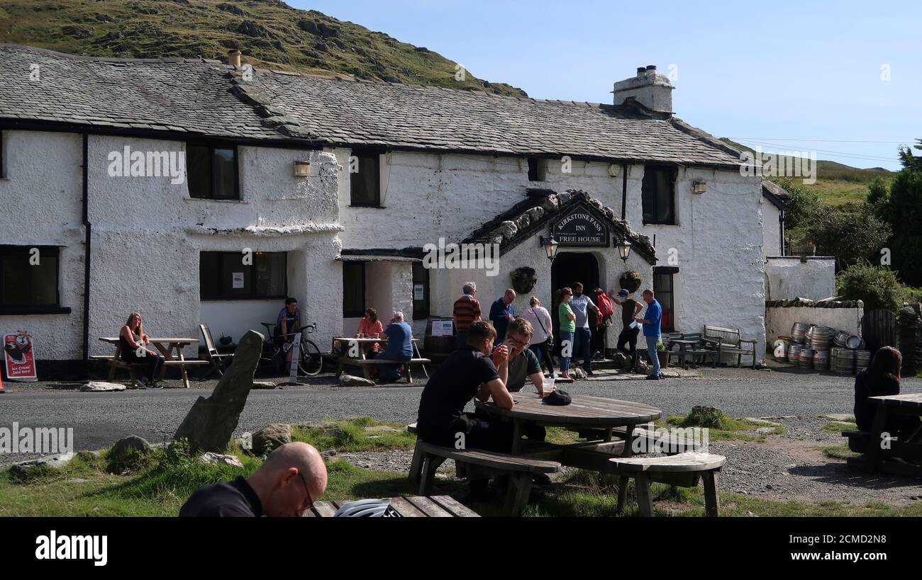 Menschen sitzen in Sonnenschein am Kirkstone Pass Inn Lake District UK Stockfoto