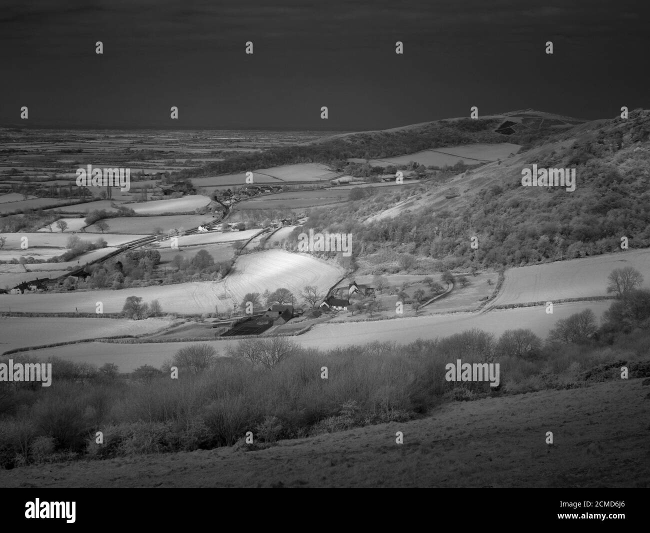 Eine Schwarz-Weiß-Infrarotaufnahme des Dorfes Compton Bishop unterhalb des Crook Peak in den Mendip Hills von Cross Plain, Somerset, England. Stockfoto