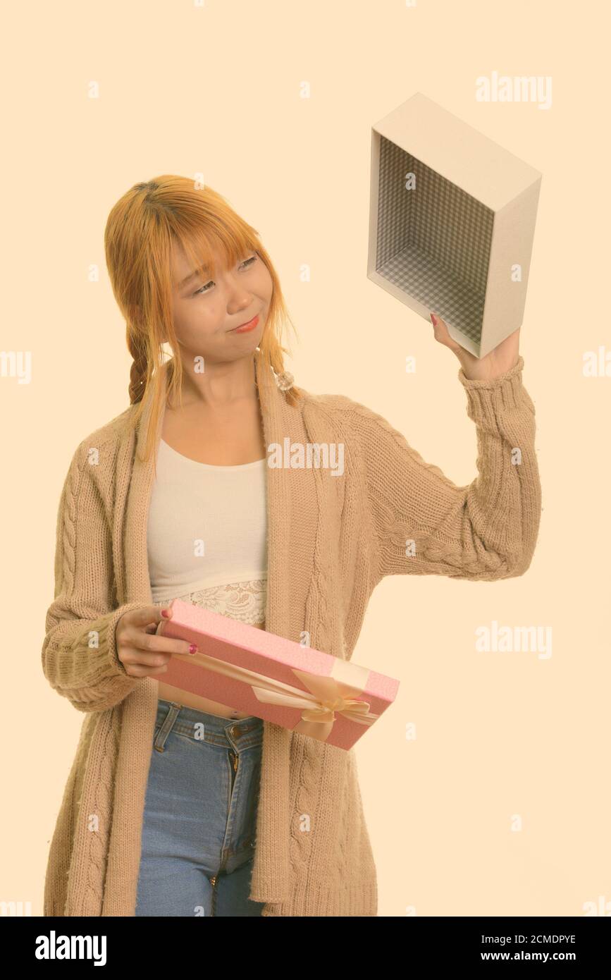 Junge süße asiatische Frau mit der Oberseite nach unten halten LEERE GESCHENKBOX, suchen enttäuscht Stockfoto