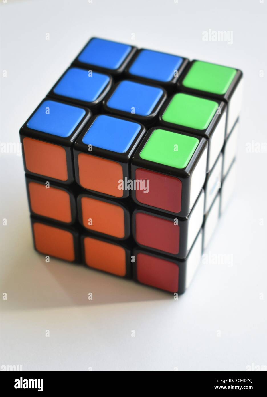 Ein isoliertes Rubik's Cube Puzzle sitzt fast auf einem gelöst Gestochen scharfer weißer Hintergrund bei hellem, natürlichem Licht Stockfoto
