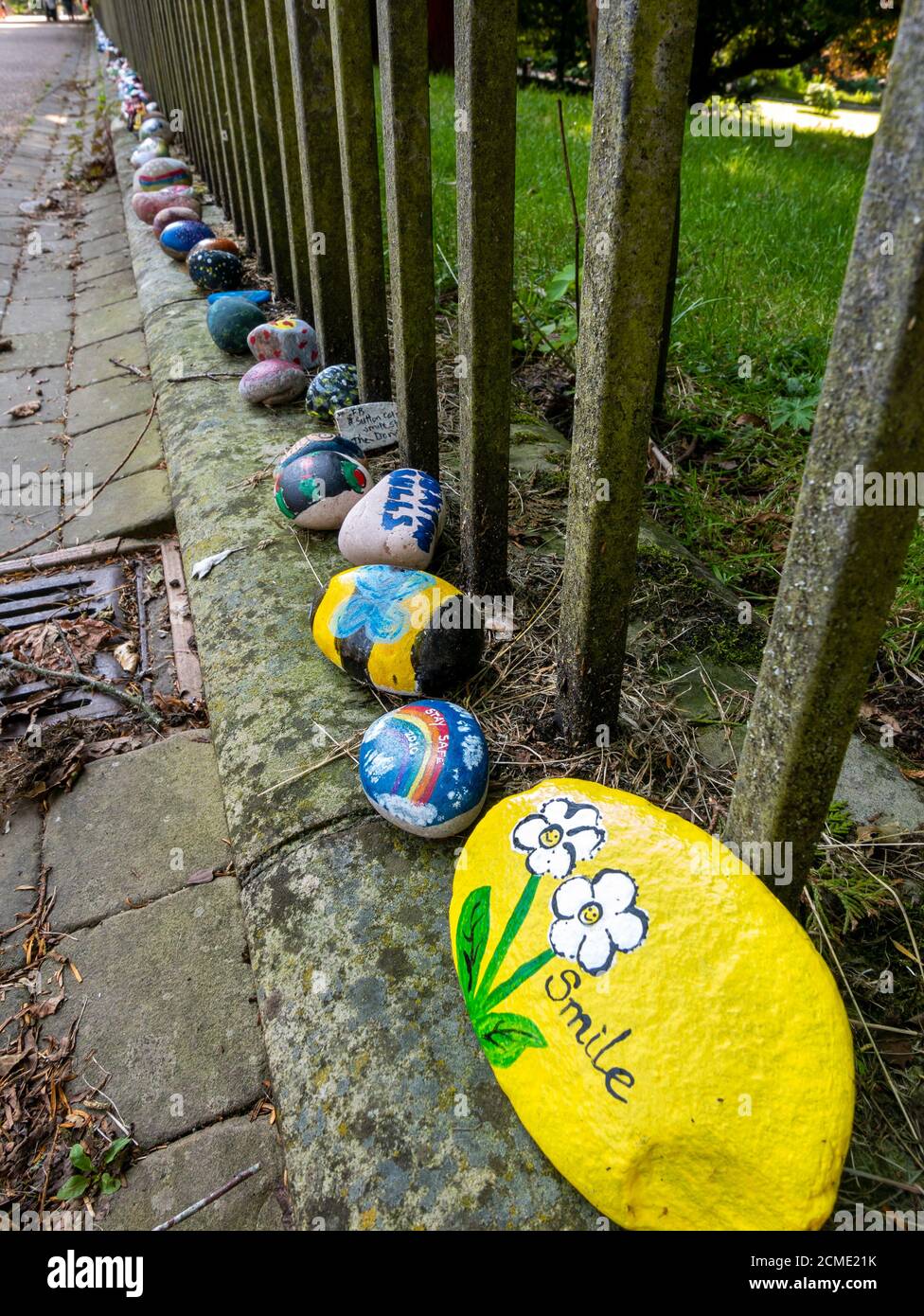 Bemalte 'Corona Stones', die eine Steinschlange erschaffen. Buxton, Derbyshire, England, Großbritannien. Stockfoto