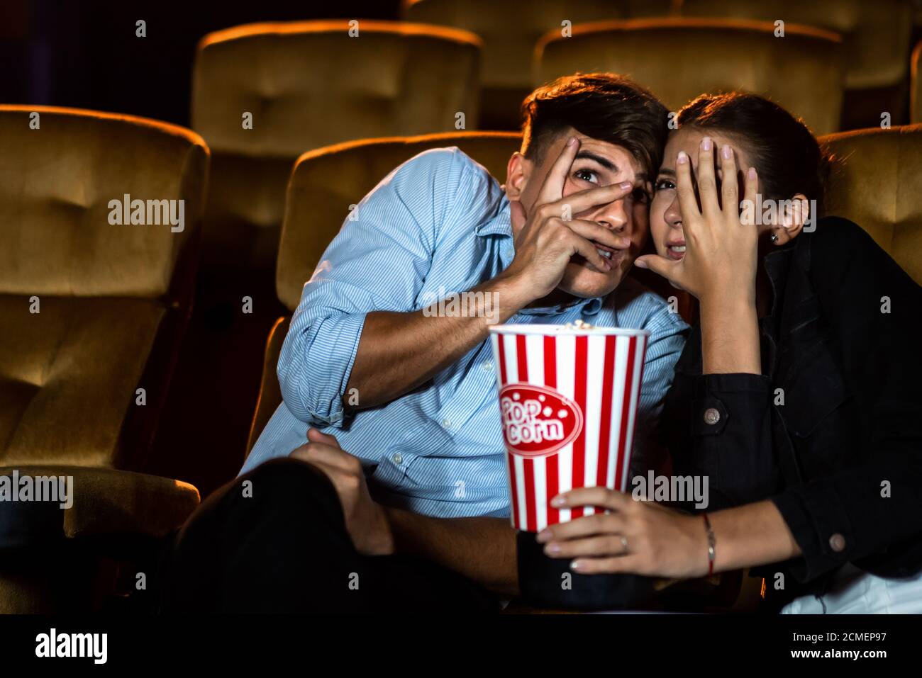 Ein paar Liebhaber, die im Kino Filmschocks und Augen sehen, schließen sich. Stockfoto