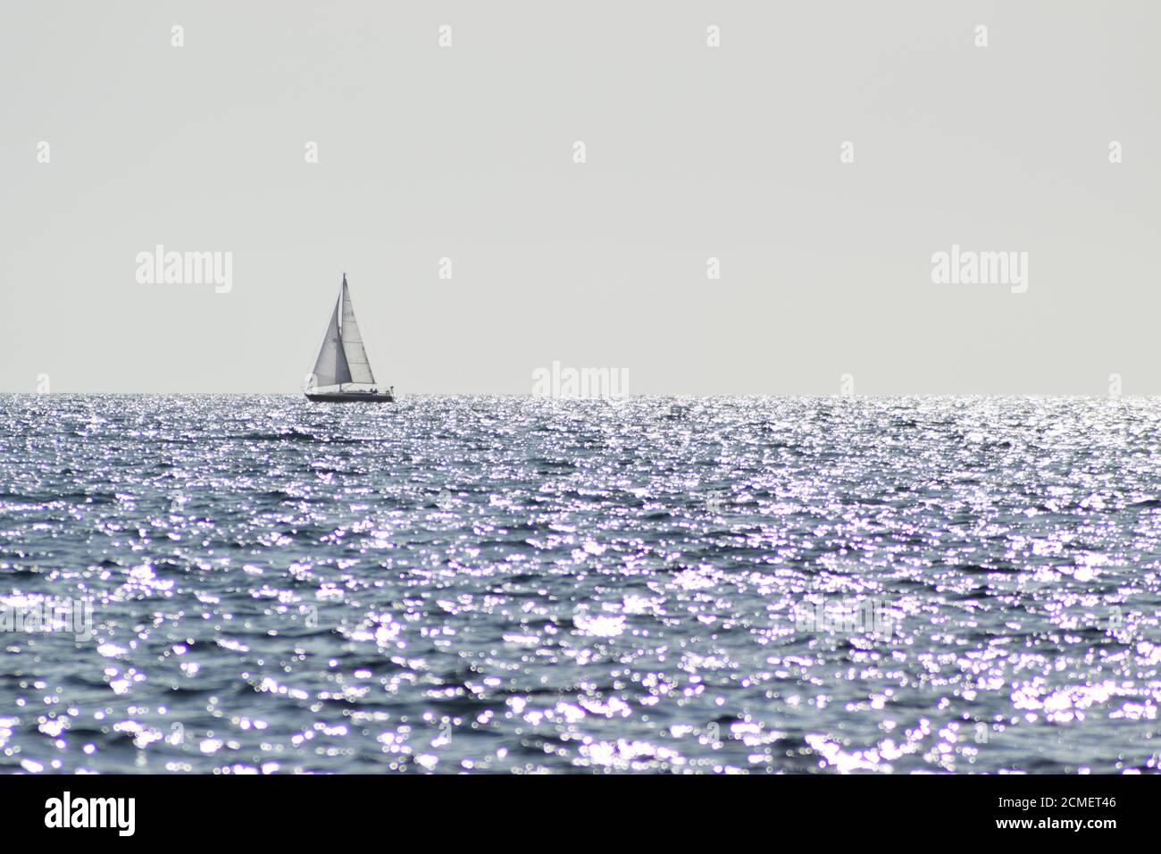 Segelboot auf glitzerndem Meer Stockfoto