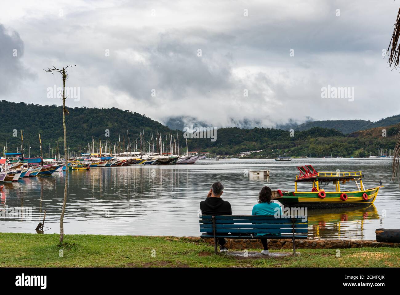 Ein Paar sitzt auf einer Bank vor der Marina Bay Brasilien Stockfoto
