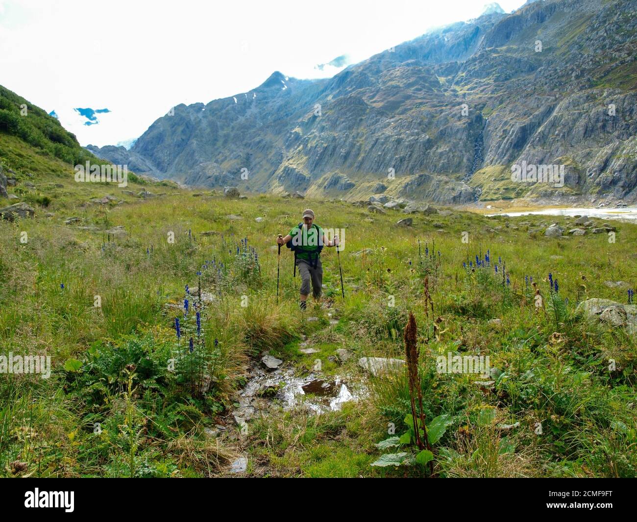 Junge Wanderer Trekking in den alpen, Schweiz, mit Bergen im Hintergrund Stockfoto