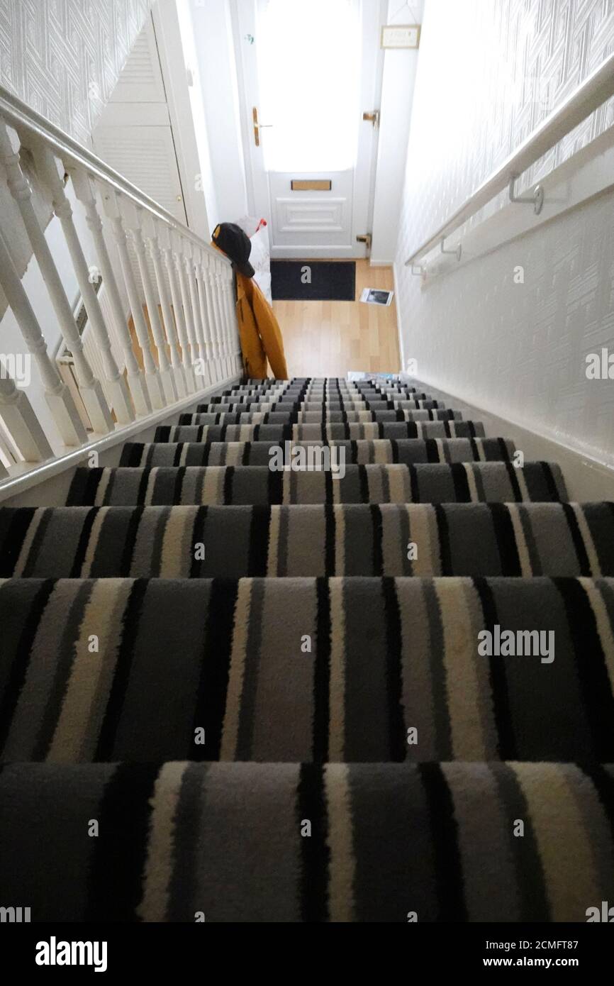 Blick auf die Haustreppe mit gestreifeinem Teppich. Vertigo-Konzept Stockfoto