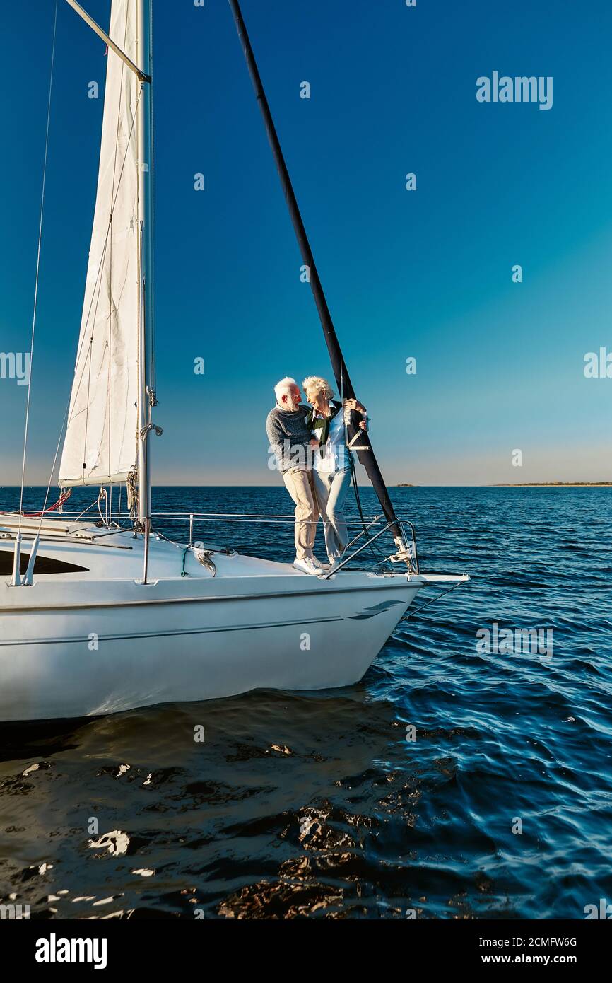 In voller Länge schöne ältere Paar in der Liebe auf dem Meer reisen, stehen sie auf der Seite des Segelboots oder Yacht Deck schwimmend im Meer Stockfoto