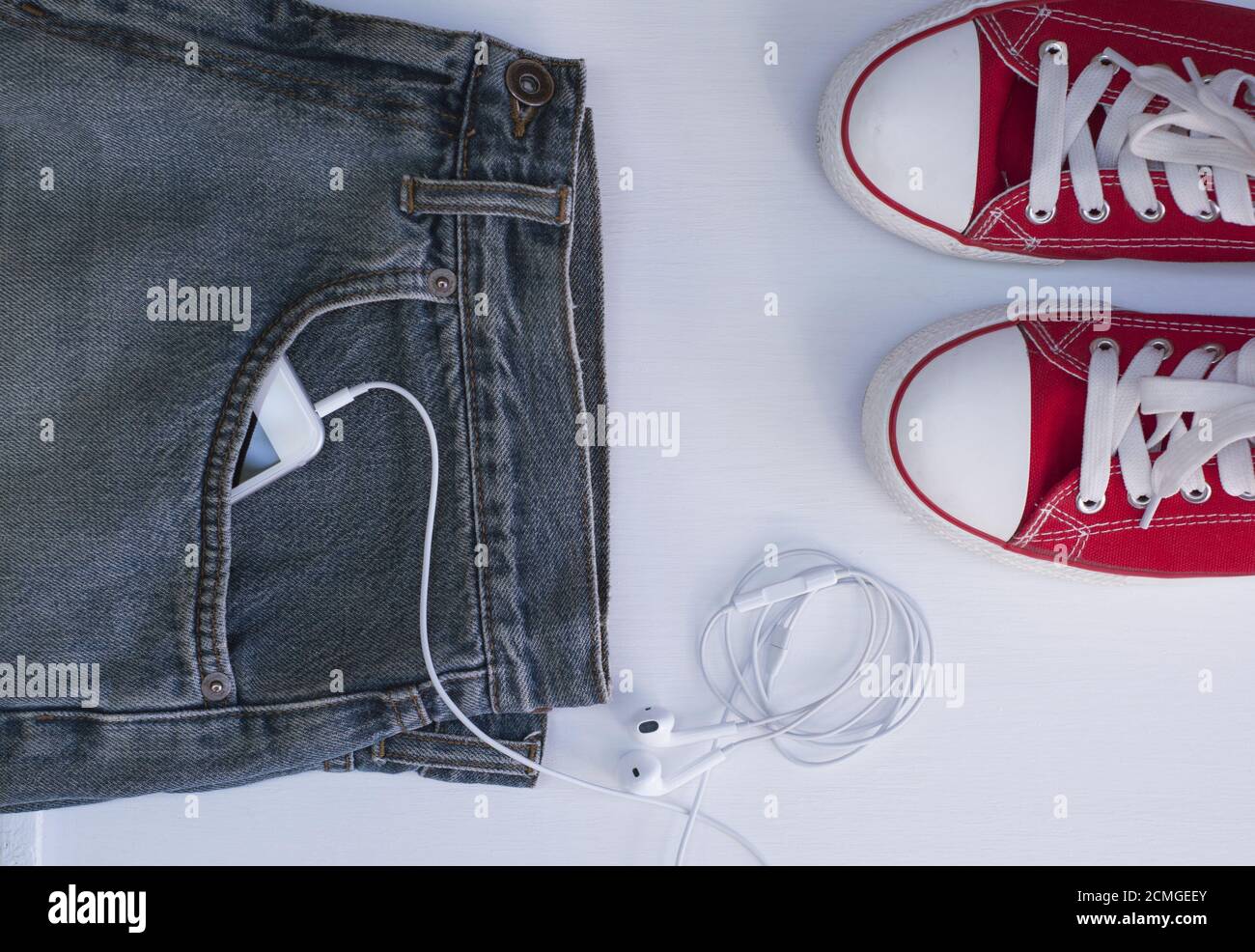 Blaue Jeans mit Handy in der Tasche bei Jugend Rote Schuhe Stockfoto