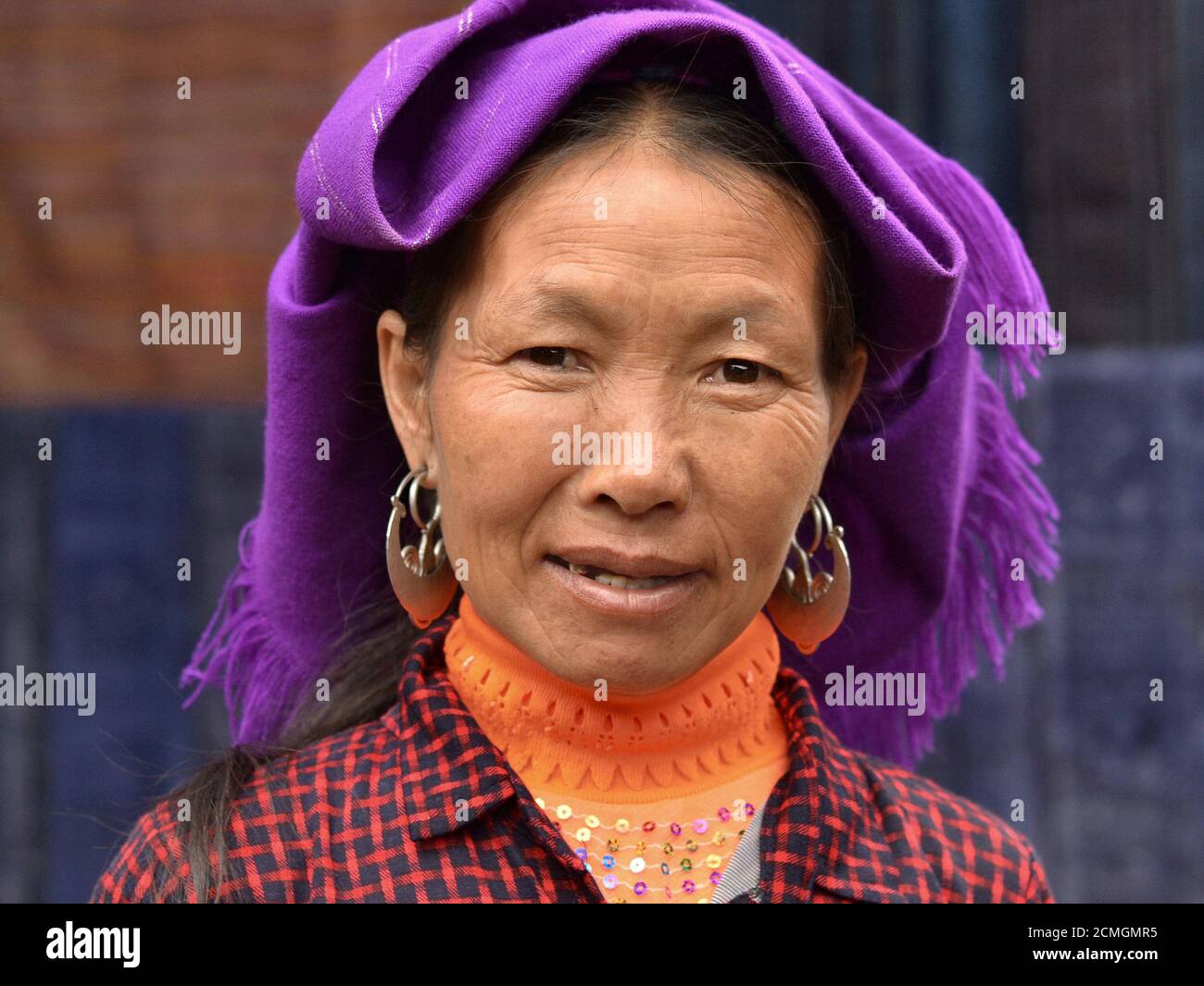 Ältere vietnamesische Hmong ethnische Minderheit Frau mit schweren Tribal Silber Ohrringe ( "Hill-Stamm Geld") posiert für die Kamera. Stockfoto