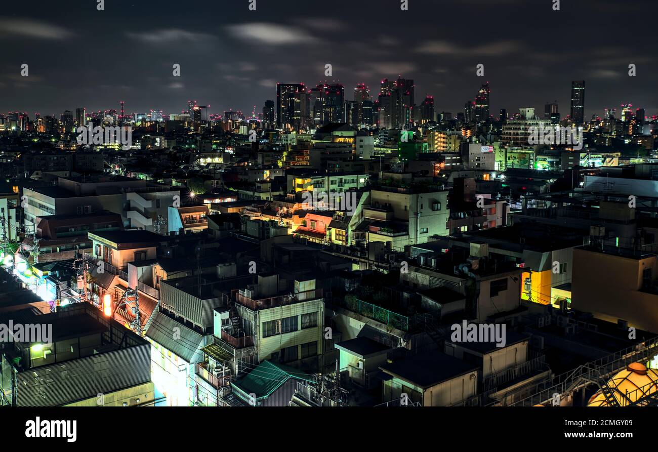 Ein Blick auf die dichte Mischung aus Geschäften und Vororten In Nakano und der Shinjuku Skyline an einem Sommerabend Unter einem leicht bewölkten Himmel Stockfoto