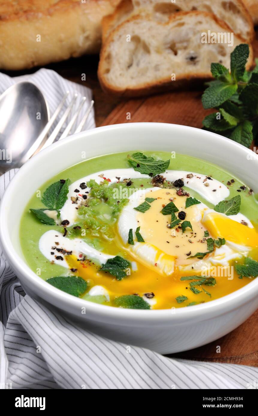 PEA-Püree-Suppe mit pochiertem Ei und Pfefferminze Stockfoto