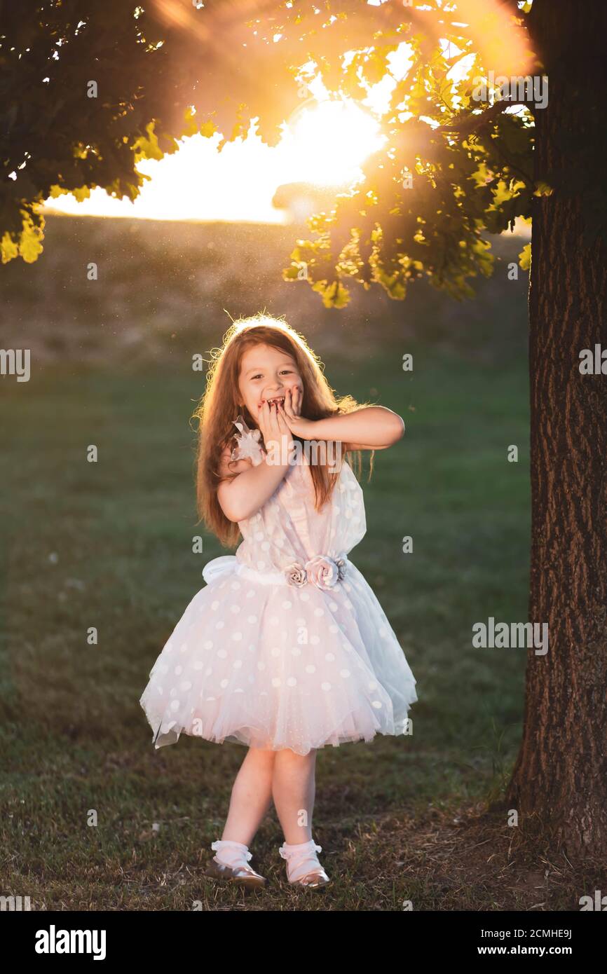 Glücklich Ingwer Mädchen in weißem Kleid, hält die Hände über den Mund, sieht überrascht Stockfoto