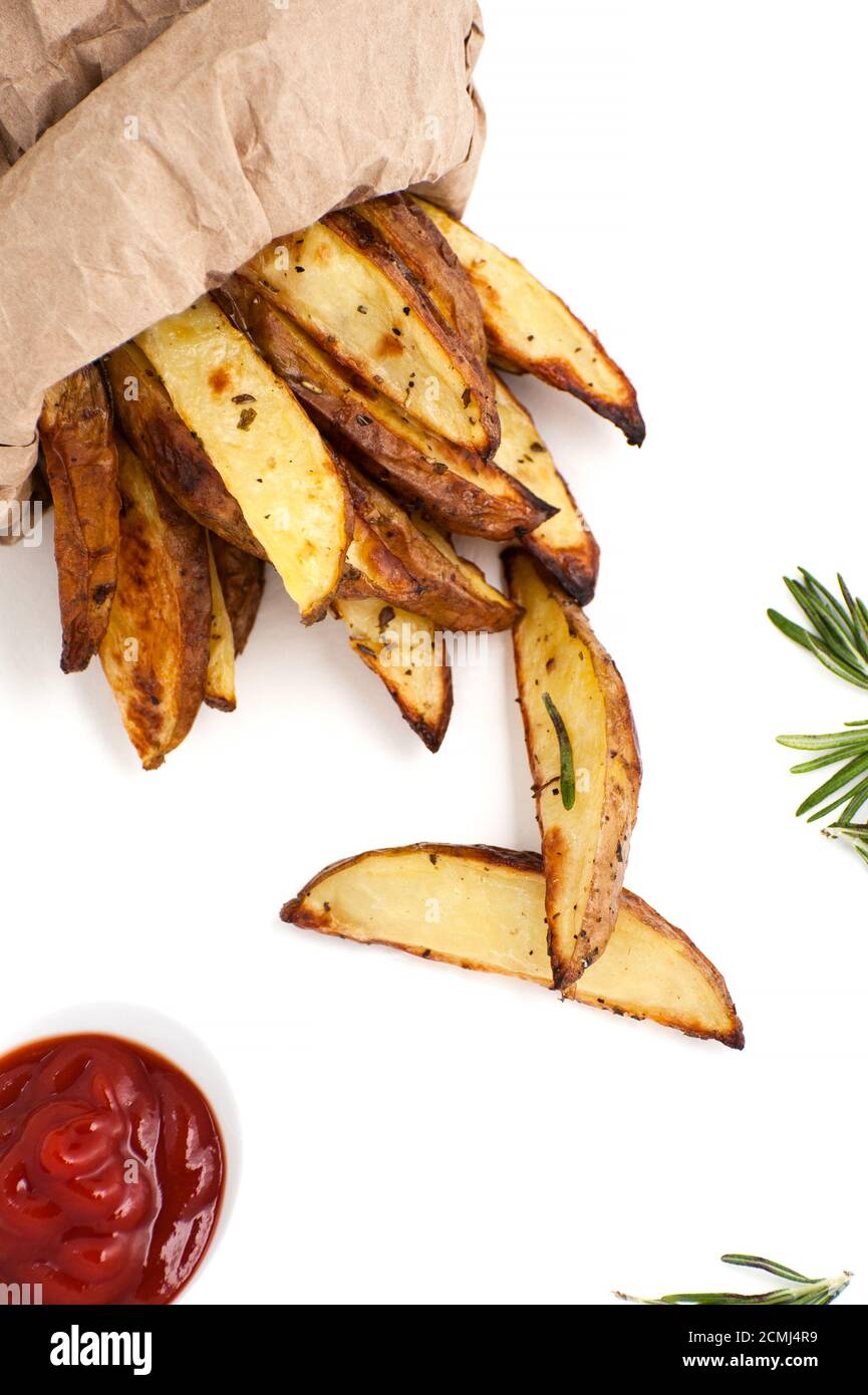 Scheiben gebackene Kartoffel mit Rosmarin und Ketchup auf weißem Hintergrund. Stockfoto
