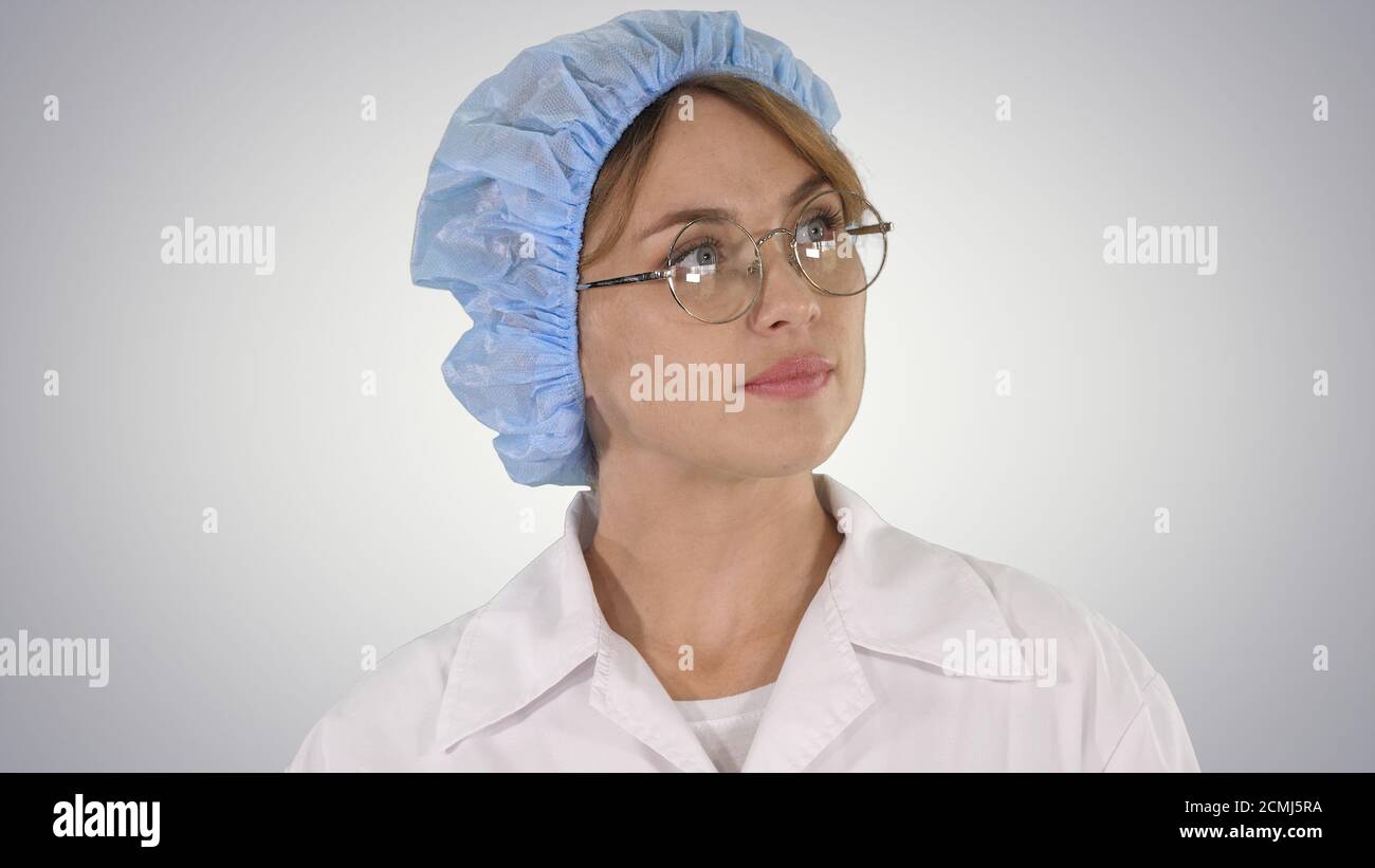 Ärztin in Brille und Hut beim Gehen und Umsehen Auf gr Stockfoto