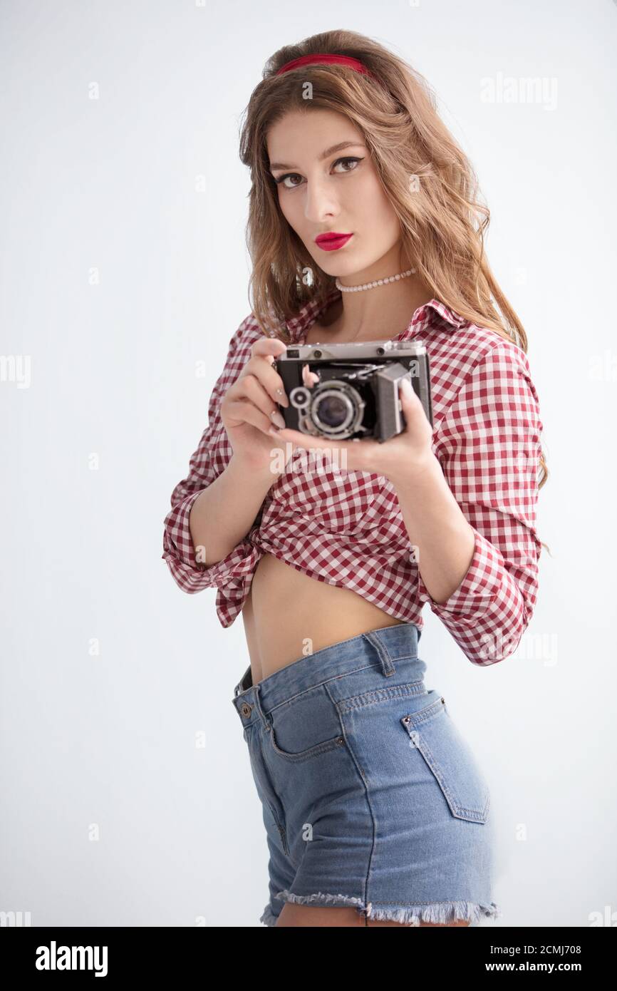 Schönes Mädchen mit Retro-Kamera. Fotografin im Stil der fünfziger Jahre Stockfoto